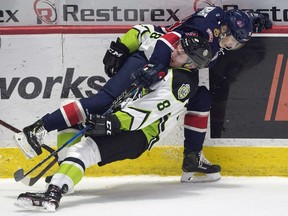 Regina Pats forward Garrett Wright, top, fights for a loose puck with the Edmonton Oil Kings' Ethan Cap in WHL action at the Brandt Centre on Friday.