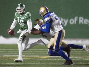 Saskatchewan Roughriders quarterback Brandon Bridge gets tackled by a Winnipeg Blue Bombers defender during second half CFL West semi-final action at Mosaic Stadium in Regina.