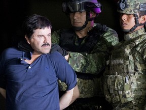 In this Jan. 8, 2016 file photo, a handcuffed Joaquin "El Chapo" Guzman is made to face the press as he is escorted to a helicopter by Mexican soldiers and marines at a federal hangar in Mexico City.