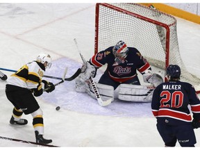 Goalie Max Paddock of the Regina Pats watches the puck as Brandon Wheat Kings forward Marcus Sekundiak tries to get a stick on it during WHL
action at Westoba Place on Thursday.