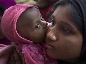 A newly arrived Rohingya refugee child licks the cheek of her mother Azida Khatoon, 20, as they wait in a food distribution line in the Kutupalong refugee camp near Cox's Bazar, Bangladesh on Jan. 27, 2018. The stripping and denial of citizenship has encouraged discrimination, persecution and violence against stateless people. For example, the genocide of Rohingya was precipitated by their being denied citizenship in Myanmar, a country they called home for generations.