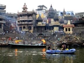 Adrian Traquair and Dustin Corkery row past the burning ghats in Varanasi. The photo was taken by Natasha Feline Jahrsdoerfer, whom they met at a hostel.