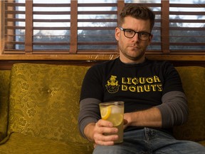 Dan Crozier, who works as a props master on film and TV sets, sits in his Regina home. His Liquor Donuts T-shirt is a reference to the movie WolfCop.