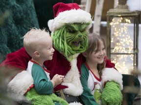 Rob Folk, local cosplayer dressed up as The Grinch, at Victoria Square Mall in Regina.  Two-year-old Brody Parsons and his seven-year-old sister Chloe get their picture taken with The Grinch.