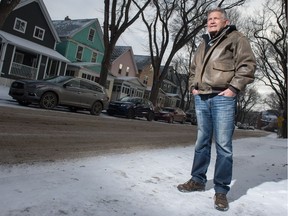 Foster Monson stands on the sidewalk in front of his home on St. John Street just south of the Regina General Hospital, where parking issues for staff and patients have become a topic of debate. Across the street, vehicles are lined up in two-hour parking spots.