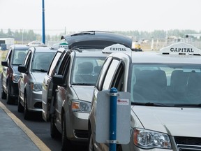 Taxi cabs sit in a line, waiting for fares, at the Regina International Airport.
