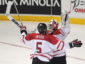 WINDSOR, ONTARIO - JANUARY 4, 2012 --  Team Ontario goaltender Spencer Martin, right is congratulated by teammate Aaron Ekblad, left after team Ontario defeated Sweden 5-2 to win the bronze medal in the 2012 World Under-17 Hockey Challenge at the WFCU Centre in Windsor, Ontario on January 4, 2012.