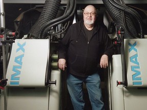 Trevor Ewen, Chief Projectionist at the Kramer Imax Theatre, stands between the twin SR 15/70 rolling loop film projectors in the projection room on the theatre's third floor. The theatre requires two projectors to screen a show in 3D. The master image is projected by the machine on the left. The image projected by the machine on the right is offset by roughly the average distance between the pupils of a person's eyes. The system uses polarizers in conjunction with the 3D glasses to provide viewers with the illusion of depth in the film.