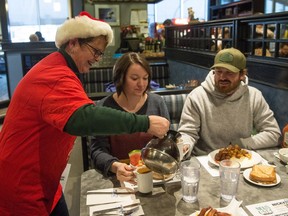 Janet Fluter of the Regina Leader-Post pours coffee for Kaili Barnes, centre, and Lance Barnes during Coffee Day at Nicky's Cafe on 8th Avenue — a fundraiser for the newspaper's Christmas Cheer Fund.