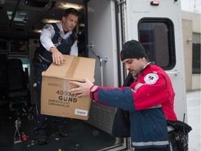 Paramedic Nikkoli Hubic, right, passes boxes of plush bears donated by the Leader-Post to paramedic Isiah Dawson to load into an ambulance outside the newspaper's Park Street office. BRANDON HARDER/ Regina Leader-Post