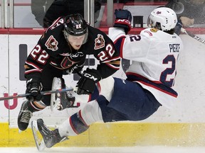 Orca Wiesblatt of the Calgary Hitmen and Duncan Pierce of the Regina Pats collide near centre ice during WHL action at the Brandt Centre on Tuesday.