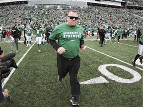 Saskatchewan Roughriders head coach Chris Jones runs onto the field after defeating the Winnipeg Blue Bombers in the Labour Day Classic at Mosaic Stadium in Regina.