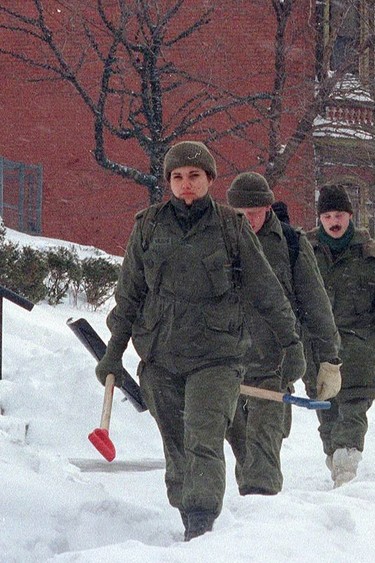 Soldiers from Royal Regiment of Canada walk with shovels on a snow-covered street on Jan. 15, 1999. (Thomas Cheng/AFP/Getty Images)
