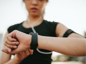 Close up shot of young sportswoman using smartwatch to track her workout performance.