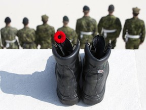 Canadian soldiers stand in a line in front of a black boot with a red poppy, representing the fallen, at the Canadian National Vimy Memorial in Givenchy-en-Gohelle, France.
