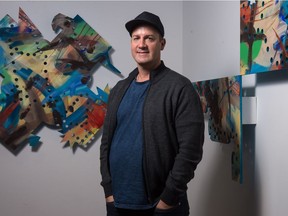 Jason Baerg stands between two pieces of his work from his exhibition Yellow Legs at the Neutral Ground gallery on Scarth Street. On the left is "Ka semakamok kîkway/ Projection." On the right is his piece "Umpehdu weeunpe dooweh eyeh / He who paints the day."