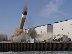 The west stack starts to fall at Ontario Power Generation's former coal-fired Nanticoke Generating Station at 11:00 a.m on Wednesday Feb. 28, 2018 in Nanticoke, Ont. The coal-fired plant was decommissioned in 2013, and is being razed to make way for a solar energy project.