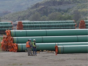 Workmen inspect steel pipe to be used in the oil pipeline construction of Kinder Morgan Canada's Trans Mountain Expansion Project at a stockpile site in Kamloops, British Columbia, Canada May 29, 2018.