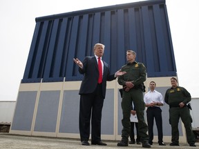 FILE - In this March 13, 2018, file photo, President Donald Trump talks with reporters as he reviews border wall prototypes in San Diego. California's attorney general filed a lawsuit Monday, Feb. 18, 2019, against Trump's emergency declaration to fund a wall on the U.S.-Mexico border. Xavier Becerra released a statement Monday saying 16 states -- including California -- allege the Trump administration's action violates the Constitution.