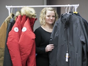 Damara Moskal, internal program manager of Mobile Crisis, holds up a new jacket that was donated in Regina.  Mobile Crisis is looking for donations of new clothing.