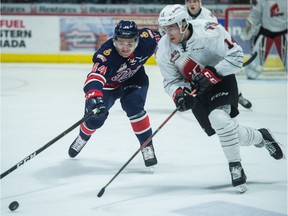 The Regina Pats' Brett Clayton, left, battles for the puck with the Moose Jaw Warriors' Luke Ormsby during a WHL game at the Brandt Centre in December.