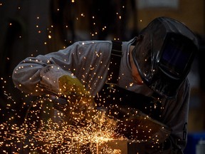 Welder Ronald Peigan grinds on a part being manufactured for use on a military vehicle at the Pro Metal Industries shop on Sherwood Road, just north of Regina.