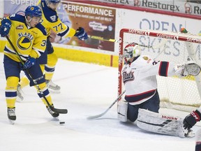 The Saskatoon Blades' Riley McKay, left, can't get the puck past Regina Pats goalie Max Paddock during Friday night's WHL game at the Brandt Centre.