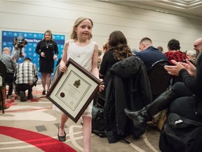 Nine-year-old Nahla Zaremba, centre, returns to her seat after being given a chief's commendation award at the Regina Police Service Awards on Feb. 5, 2019.