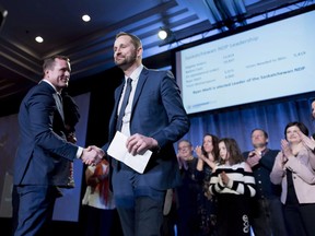 Trent Wotherspoon, left, shakes hands with Ryan Meili, center, after the results of the Saskatchewan New Democrats leadership convention are announced in Regina on March 3, 2018. Saskatchewan NDP leader Ryan Meili says the provincial government isn't doing enough to combat child hunger and child poverty. A Food Banks Canada report for 2018 shows that Saskatchewan has the highest rate of children using food banks in the country.