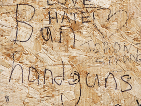 A message written on a makeshift memorial remembering the victims of a shooting on Toronto’s Danforth Avenue calls for a ban on handguns.