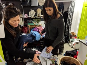 Noy Phonsavath (left) and Sarah Middlemiss, owners of the local consignment shop Underground Trends, sort through some of the items people have brought into the shop to sell after being inspired by Marie Kondo's new Netflix show, on February 9, 2019. (Erin Petrow/ Saskatoon StarPhoenix)