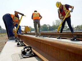 Workers install the first rail for the Valley Line LRT Phase 1 in Mill Woods on Aug. 9, 2018, in Edmonton.