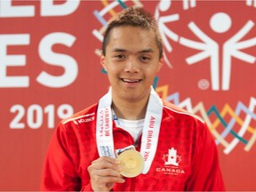 Regina swimmer Michael Qing is shown with one of the three gold medals he won at the Special Olympics World Games in March.