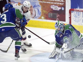 The Swift Current Broncos' Matthew Stanley  tries to check the Regina Pats' Blake Allan off the puck in front of goalie Isaac Poulter in WHL action at the Brandt Centre in Regina..