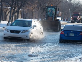 A vehicle travels along a very flooded portion of 14th Avenue near Montreal Street where work crews were arriving to deal with a water main break on Saturday, March 9.