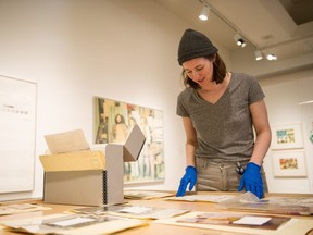 Alex King, co-curator of Superscreen: The Making of an Artist-Run Counterculture and the Grand Western Canadian Screen Shop, finishes arranging some photographs and artifacts for display at the MacKenzie Art Gallery.