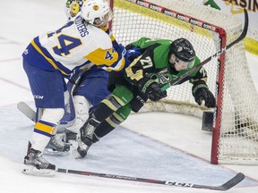 Saskatoon Blades forward Chase Wouters checks Prince Albert Raiders forward Parker Kelly during the first period of WHL playoff action at SaskTel Centre in Saskatoon on Sunday, April 14, 2019.