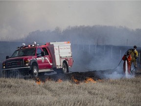 Members of the Saskatoon Fire Department battle a large brush fire along Strathcona Avenue near Cranberry Flats outside of Saskatoon, SK on Tuesday, April 16, 2019.