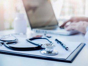 Stethoscope with clipboard and Laptop on desk Doctor working in hospital writing a prescription  Healthcare and medical concept test results in background vintage color selective focus.