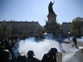 Protesters and anti-riot police stand amid tear gas at the Place de la Republique.