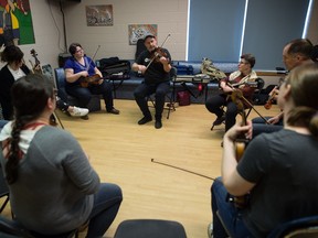 People take part in a fiddle workshop held at the Core Ritchie Neighbourhood Centre. At centre, seen in a hat and black shirt is instructor Troy MacGillivray.