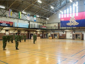 The camp flag of the 10th Field Artillery Regiment, RCA is raised in the Regina Armoury on Elphinstone Street while members of the reserve unit look on.