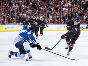 Canada's Maxime Comtois (14) misses a shot at the empty net as Finland's Urho Vaakanainen (7) defends after they pulled their goalie from the game for an extra skater during third period IIHF quarter-final IIHF world junior hockey championship action in Vancouver on Wednesday, Jan. 2, 2019.