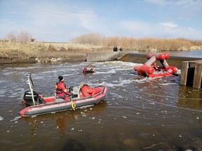 Members of the RCMP's underwater recovery team, assisted by the Saskatoon Fire Department, search the area where Ernest Severight was last seen when he fell into the Assiniboine River near Kamsack on April 23. (Photo courtesy RCMP)