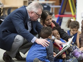 Regina MP Ralph Goodale speaks with a family at the Regina Public Library main branch after an announcement of provincial and federal funding for literacy initiatives for children aged six and under across the province.