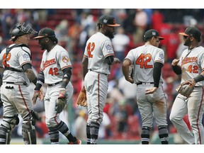 Baltimore Orioles' Miguel Castro, center, and Jesus Sucre, left, celebrate with teammates after defeating the Boston Red Sox during a baseball game in Boston, Monday, April 15, 2019. The players are all wearing (42) in honor of Jackie Robinson Day.
