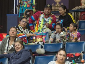 From top left, Nolan Smallboy-Roan and Samantha Bearboy sit together during the First Nations University Powwow held at the Brandt Centre. Below them are their children, from left, Taris Smallboy, Uriah Smallboy and Amrie Smallboy.