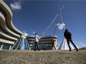 Peter Brass, right, along with students Trad Sparvier, left, and Troy Isnana, centre, work on taking down one of four teepees in front of First Nations University of Canada in Regina.