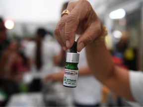 A distributor holds a vial of medicinal cannabis oil during the second day of the inaugural Pan Ram weed festival in the Thai northeastern province of Buriram on April 20, 2019.