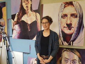 Saskatoon artist Carol Wylie in her studio with paintings from her series entitled "They didn't know we were seeds," which honours survivors of the Holocaust and Canada's residential schools. (photo by Joanne Paulson)